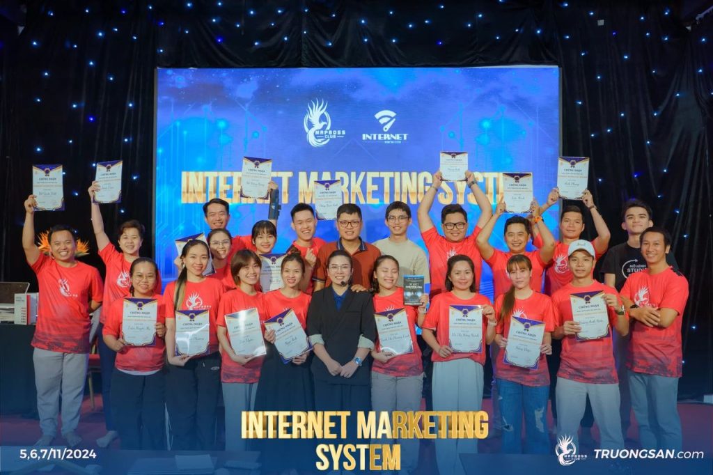 Cả lớp IMS mùa 1 áo đỏ giơ cao giấy chứng nhận trên sân khấu