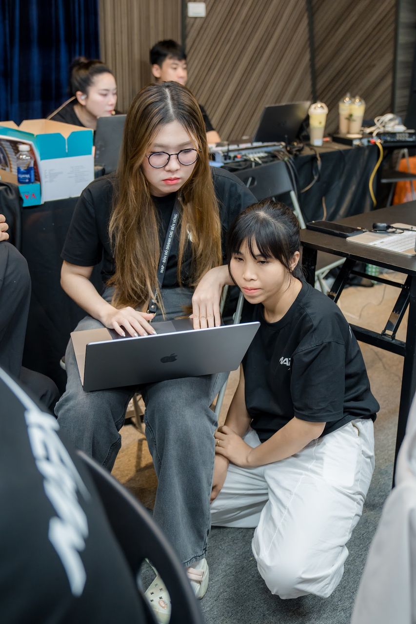 Hai học viên IMS mùa 2 cùng dò thao tác trên một chiếc laptop