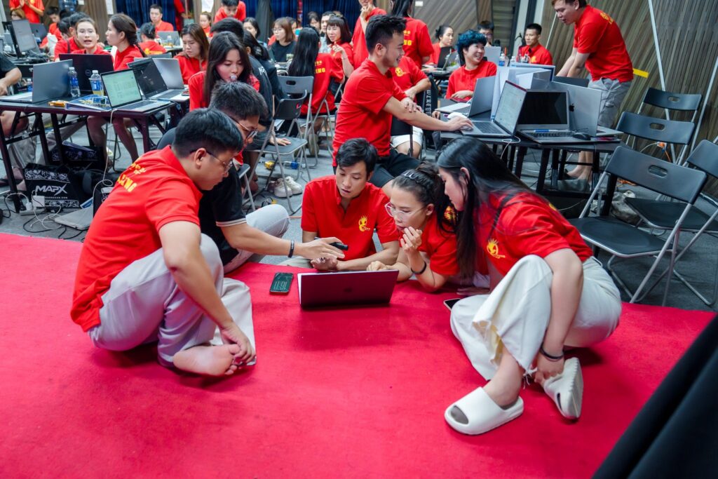 Học viên IMS K02 ngồi làm bài nhóm với máy tính trên sàn