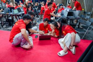 Học viên IMS K02 ngồi làm bài nhóm với máy tính trên sàn