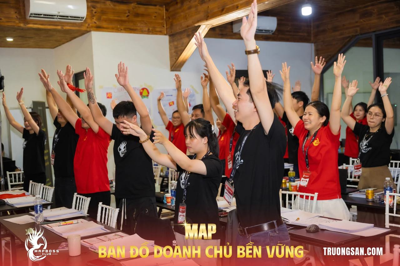 Cả lớp MAP CAMP mùa 19 đứng dậy giơ tay trong gian phòng gỗ