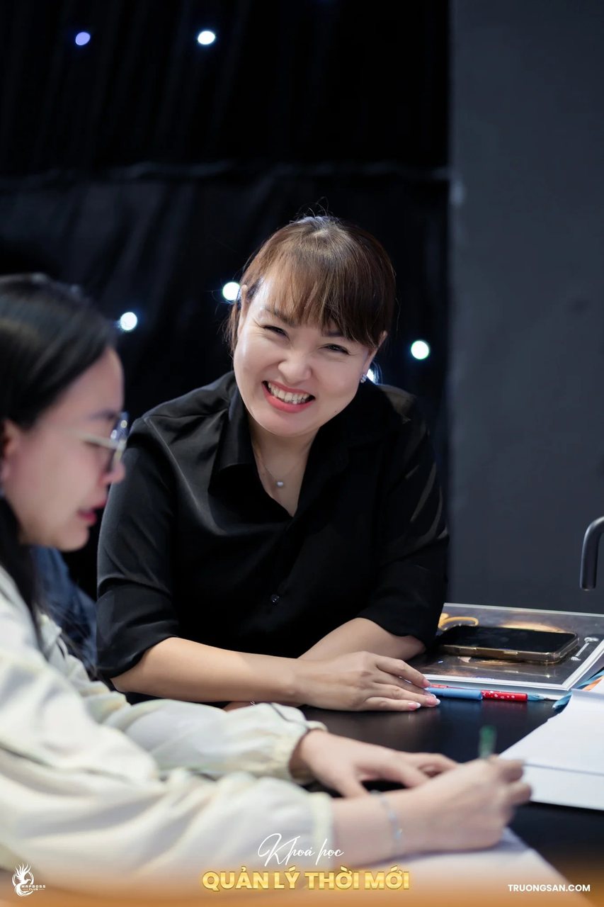 Nữ học viên Quản Lý Thời Mới mùa 3 cười tươi bên bàn làm bài
