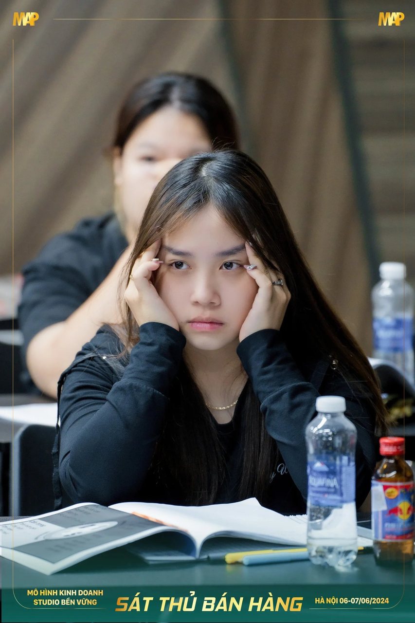 Nữ học viên Sát Thủ Bán Hàng ôm đầu suy nghĩ trước cuốn tài liệu