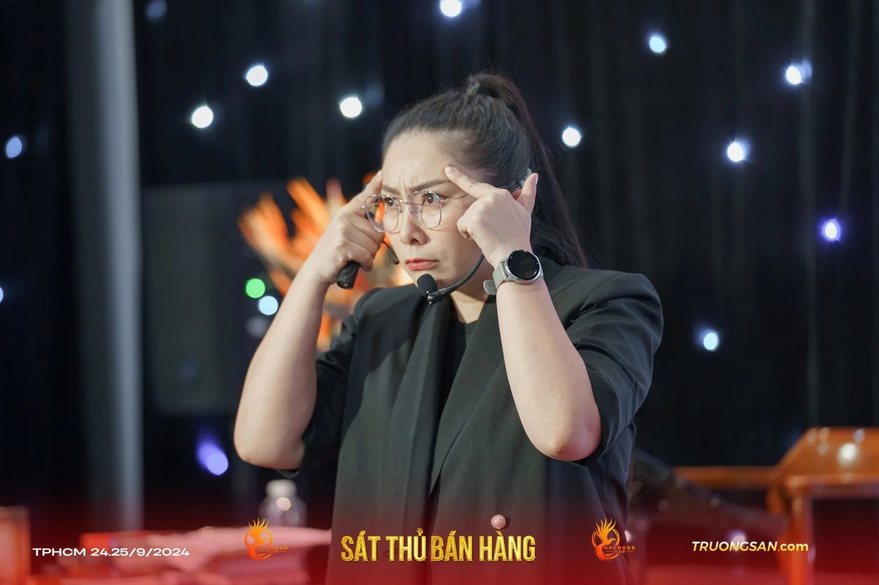 Người dẫn dắt Sát Thủ Bán Hàng đặt tay lên thái dương khi giảng bài