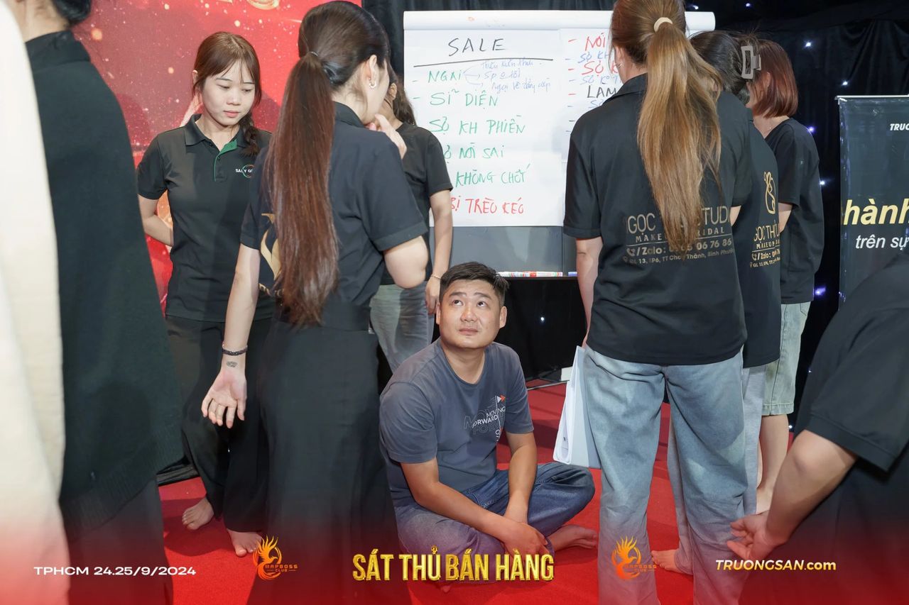 Học viên Sát Thủ Bán Hàng đứng quanh bảng lật tập tình huống bán hàng