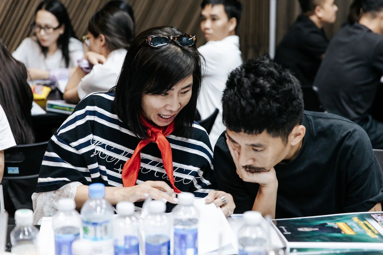 Hai học viên Video Marketing mùa 10 chăm chú đọc tài liệu bên bàn đội
