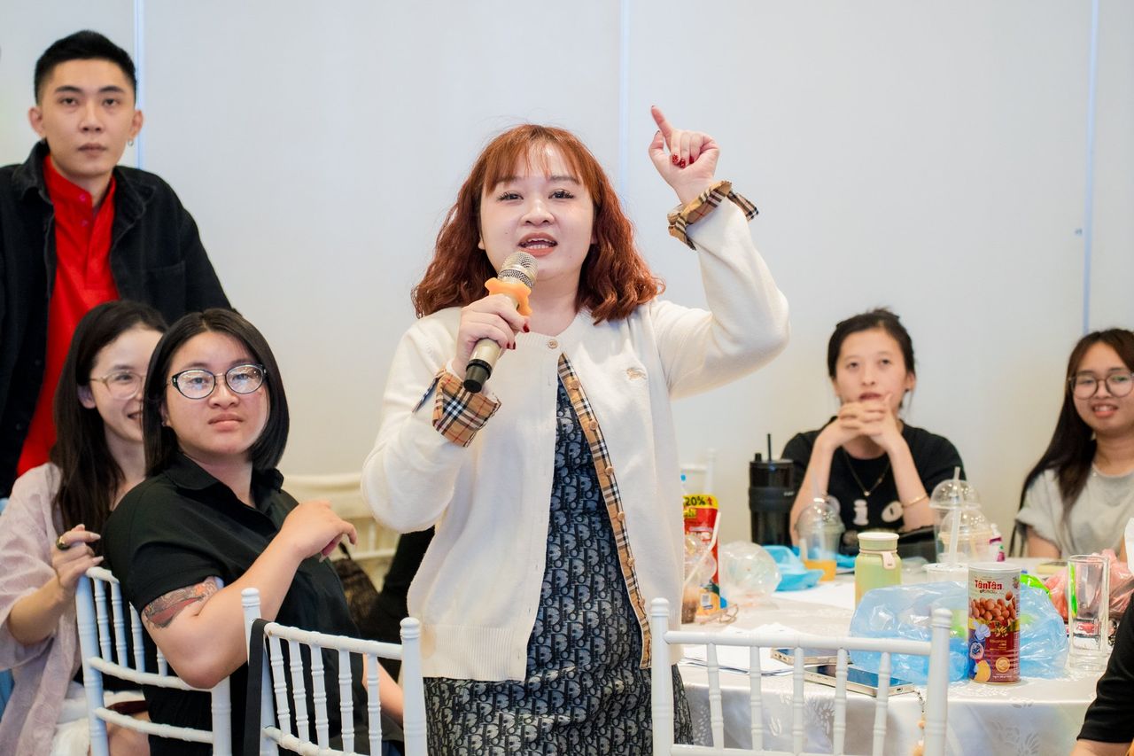 Nữ học viên Video Marketing mùa 11 hào hứng cầm micro chia sẻ tại bàn