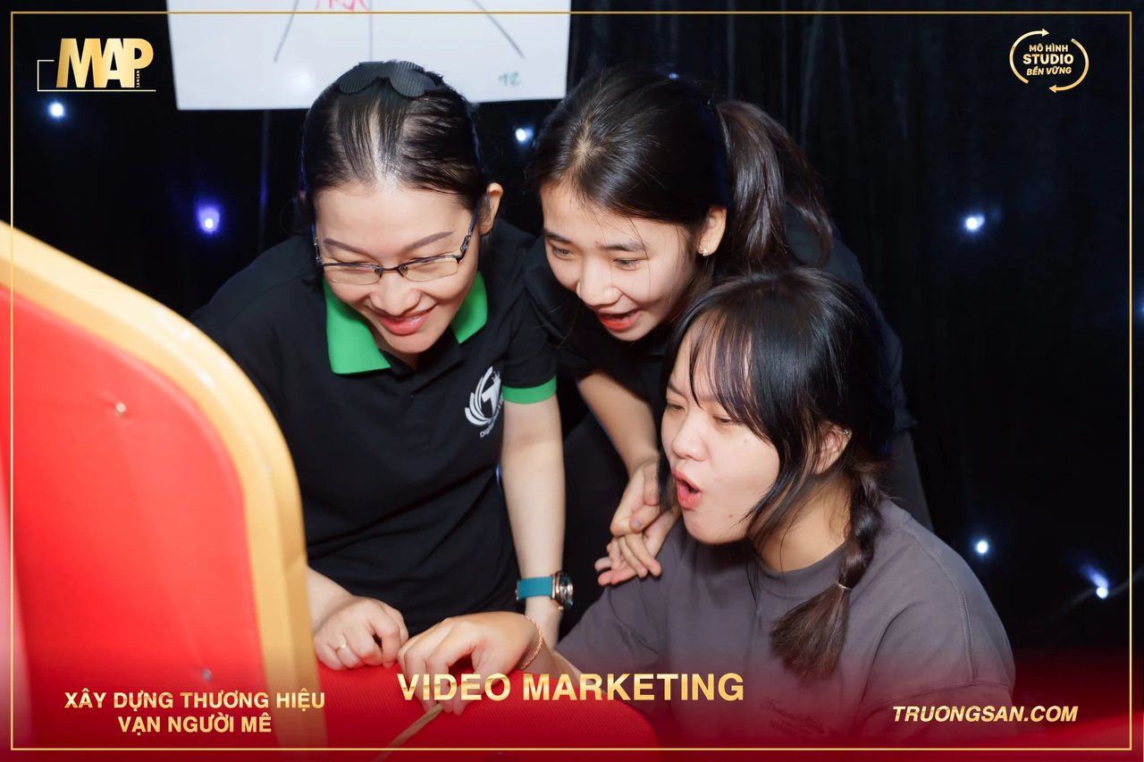 Ba học viên Video Marketing mùa 6 chụm đầu cúi nhìn trong giờ thực hành