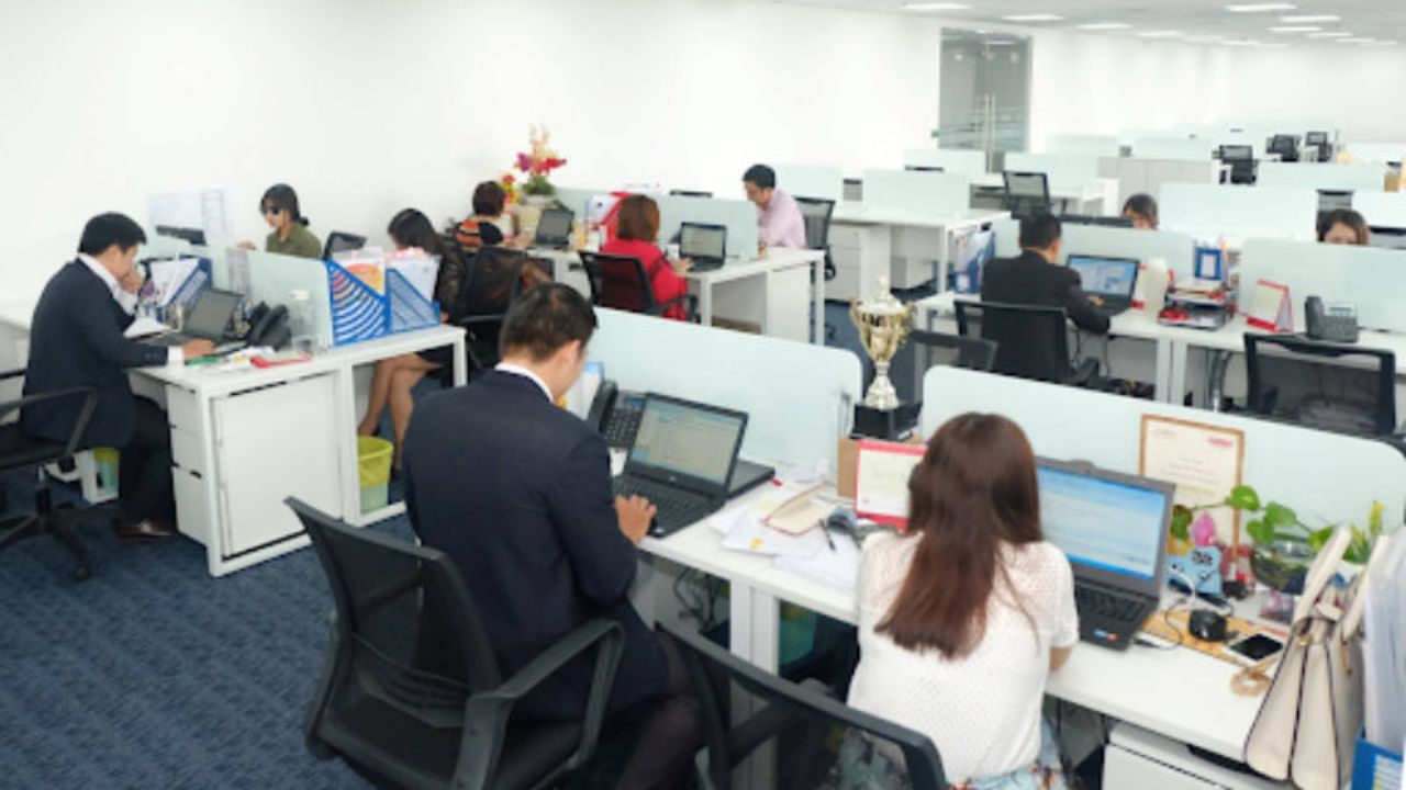 Nhân viên văn phòng làm việc với máy tính và tài liệu, minh họa các nhiệm vụ hành chính, nhập liệu và xử lý hồ sơ có khả năng được tự động hóa bằng trí tuệ nhân tạo (AI).