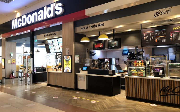 Không gian cửa hàng McDonald’s với quầy gọi món, nhận hàng, menu và hệ thống nhận diện thương hiệu đồng bộ