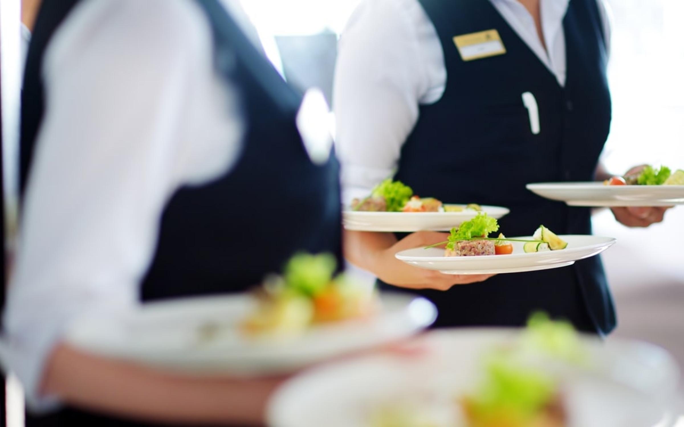 Nhân viên phục vụ món ăn trong nhà hàng, minh họa hoạt động Trade Marketing tại kênh HoReCa và F&B